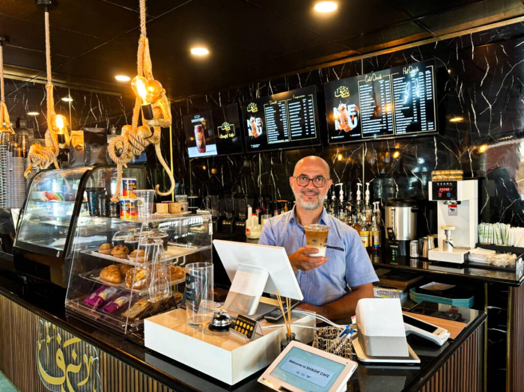 A staff serving the drink at Shaghf Cafe