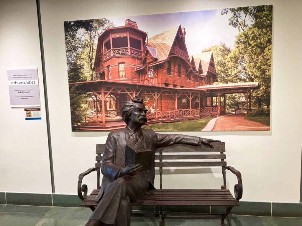 A statue sitting on a bench inside the Mark Twain House and Museum in Hartford