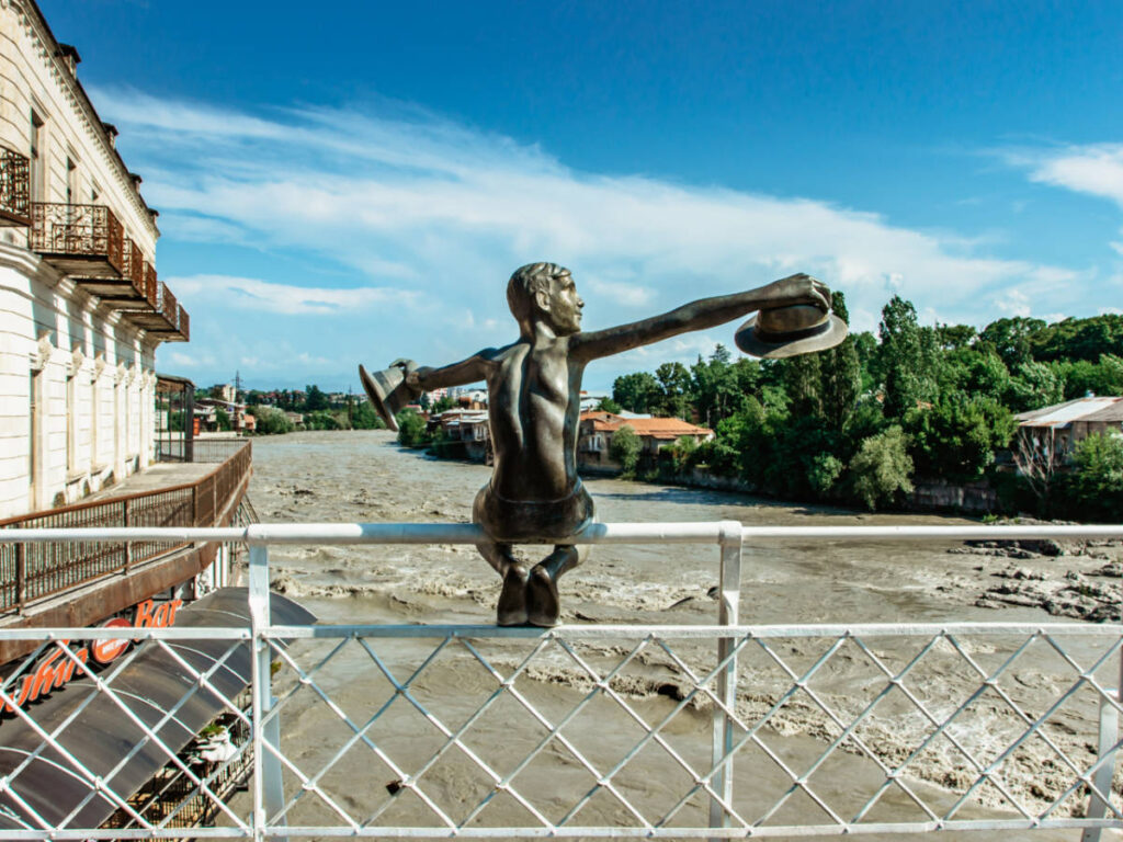 A statue sitting on the railing of the Kutaisi Bridge