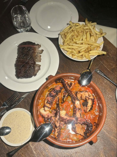 Variety of dishes of steak, octopus and chips from Ibai