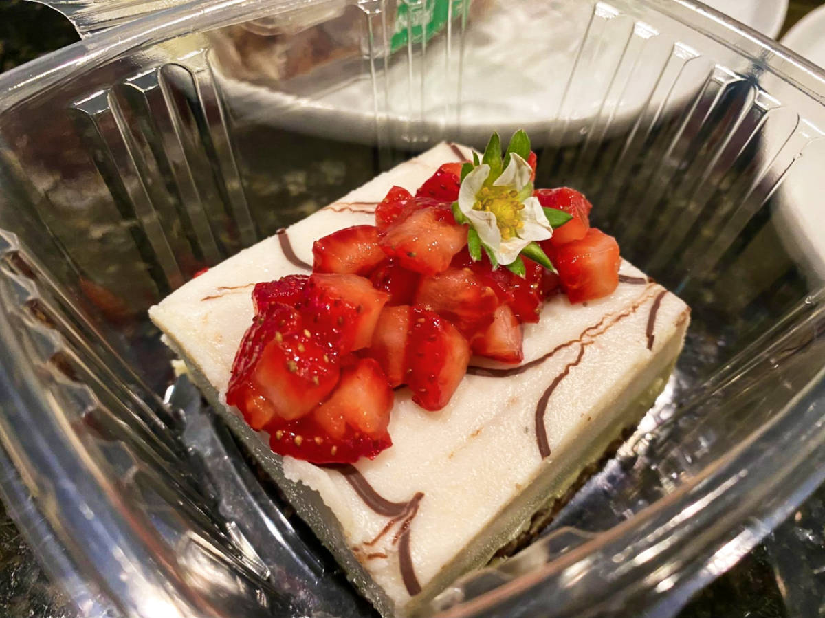 A sliced cake topped with diced strawberries