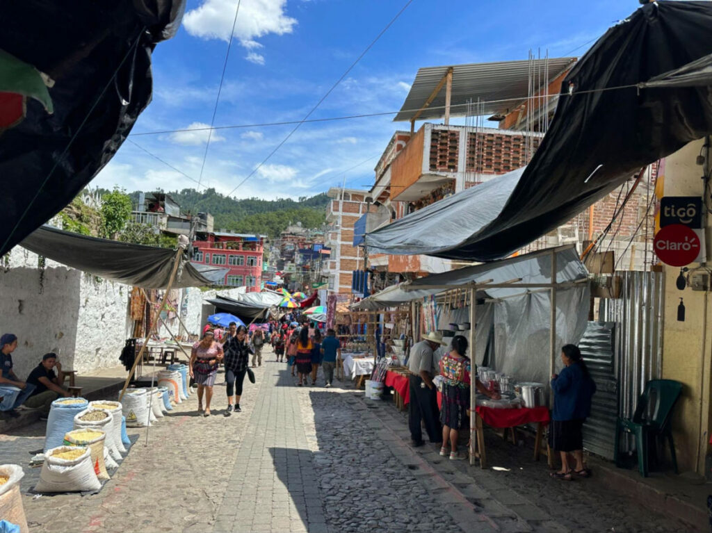 Street market in Chichicastenango, Guatemala, with people strolling around and vendors on the sides
