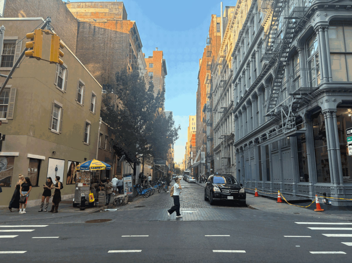 A lady walking on a cobblestone street in SoHo