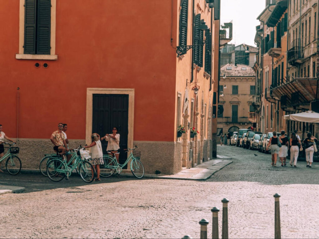 People wandering and holding their bike at the streets of Verona