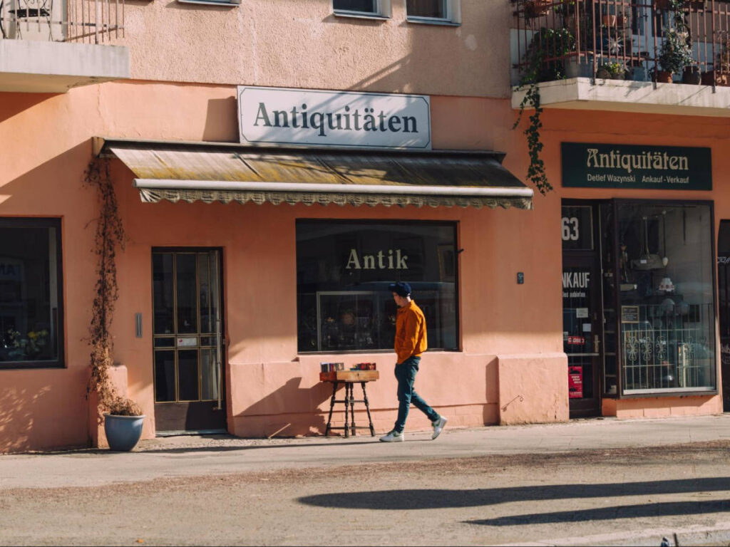 A man walking in front of the antique store in Suarezstraße