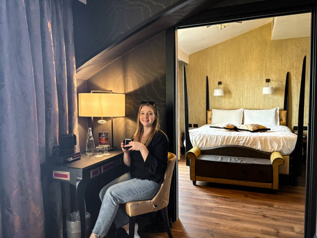 The author, Taylor Hererger holidng a mug on her suite at Palazzo Veneziano