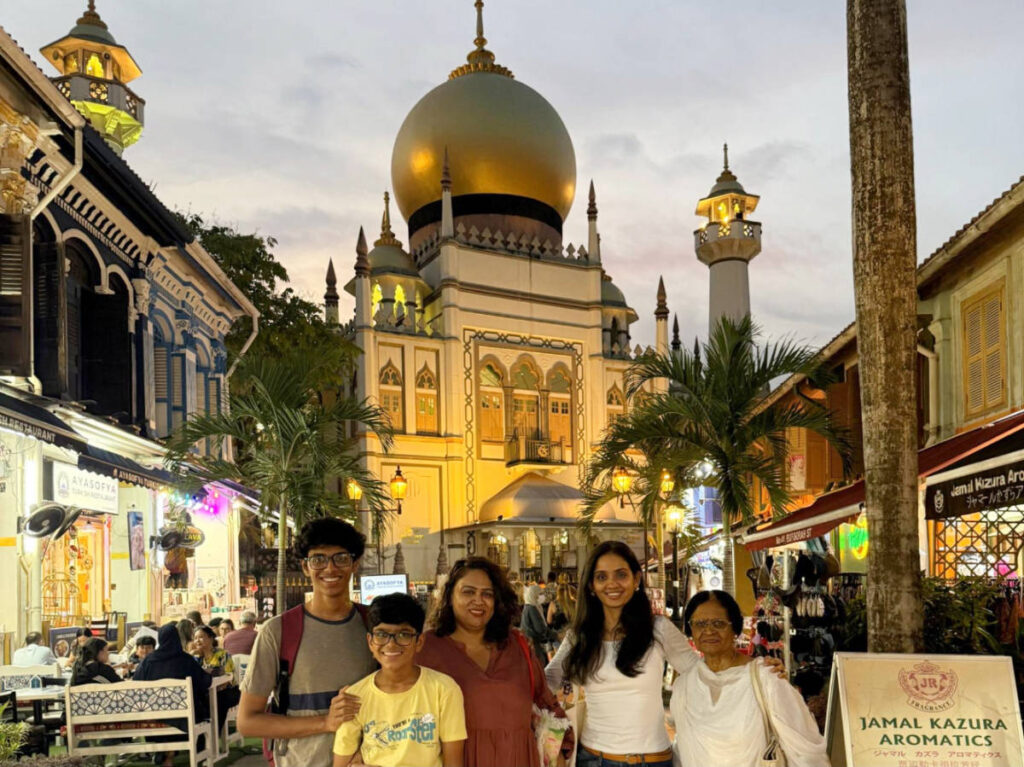 The author, Advaita with her family ad the Sultan Mosque on their background