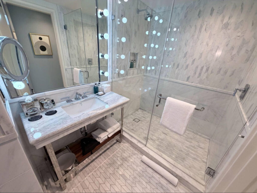 View of the clean and marbled interior of the bathroom in the room of the Sun Rose