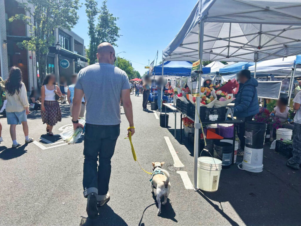 The author's husband and their dog at the Sunday Farmers Market