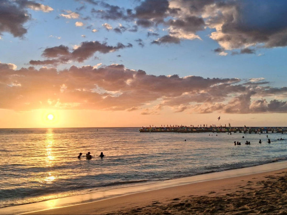 People enjoying the beach of Crash Boat Beach at sunset