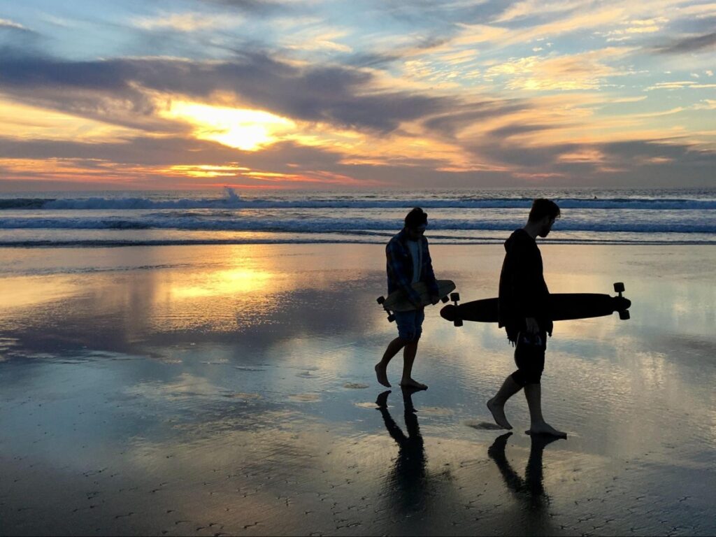 Beachgoers walking at Mission Beach during sunset