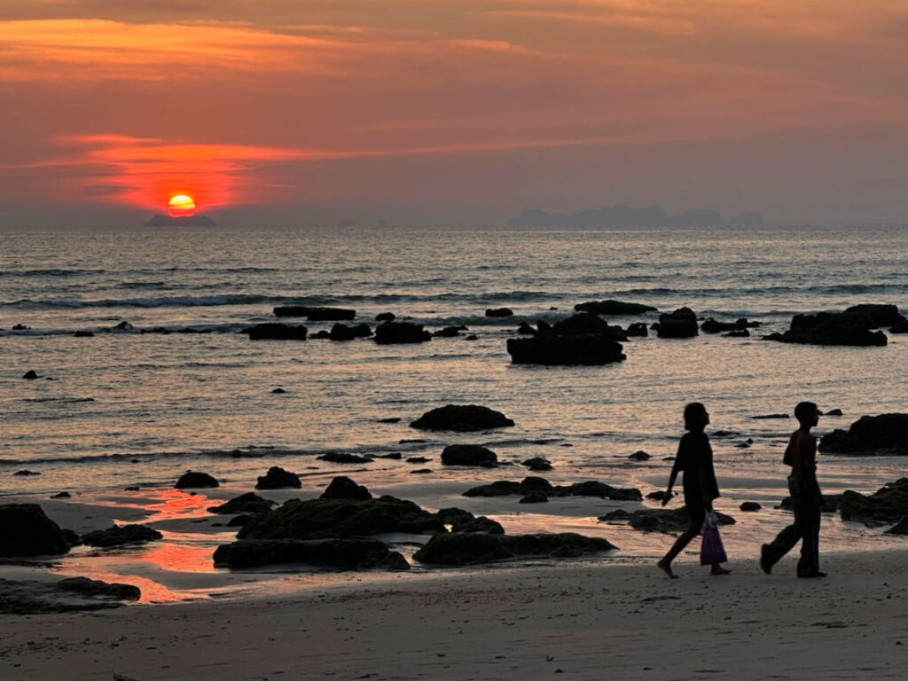 Children walking along the beach at sunset in Koh Lanta