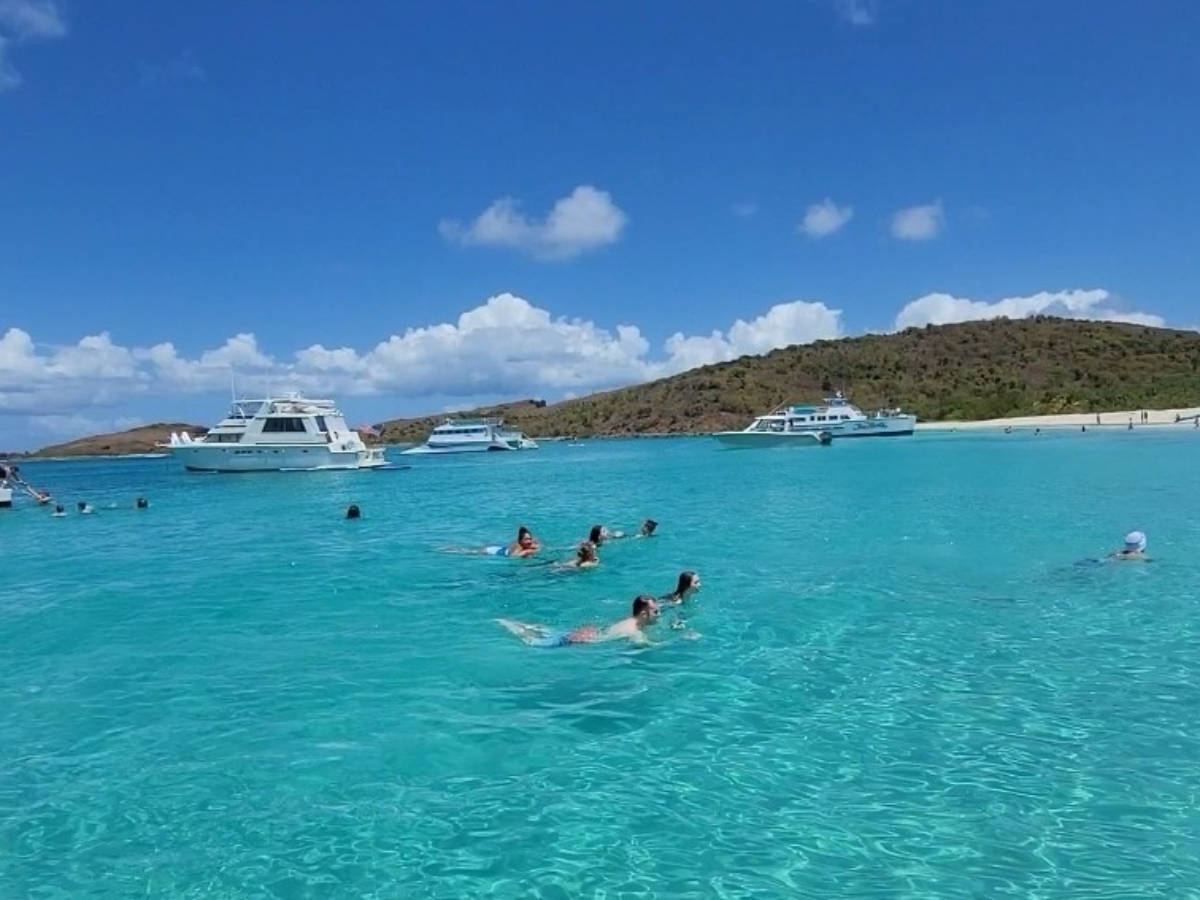 People swimming in the blue waters of Culebrita