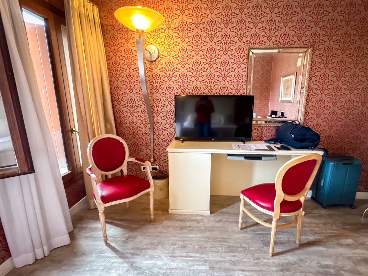 A television on a table with chairs at Hotel Principe