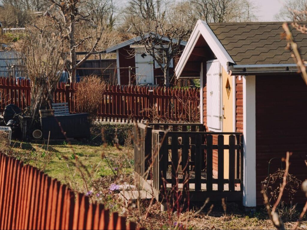 Cottages with red-painted wooden fences at Tantolunden