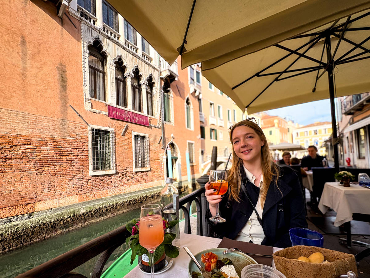The author Taylor Herperger, drinking aperol spritz & cicchetti at Ristorante Dell'Osmarin