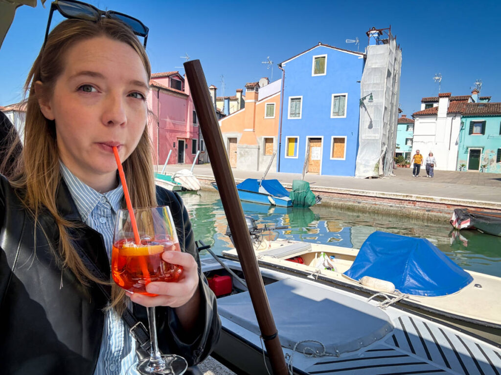 The author Taylor Herperger, enjoying her drink in front of the colorful buildings