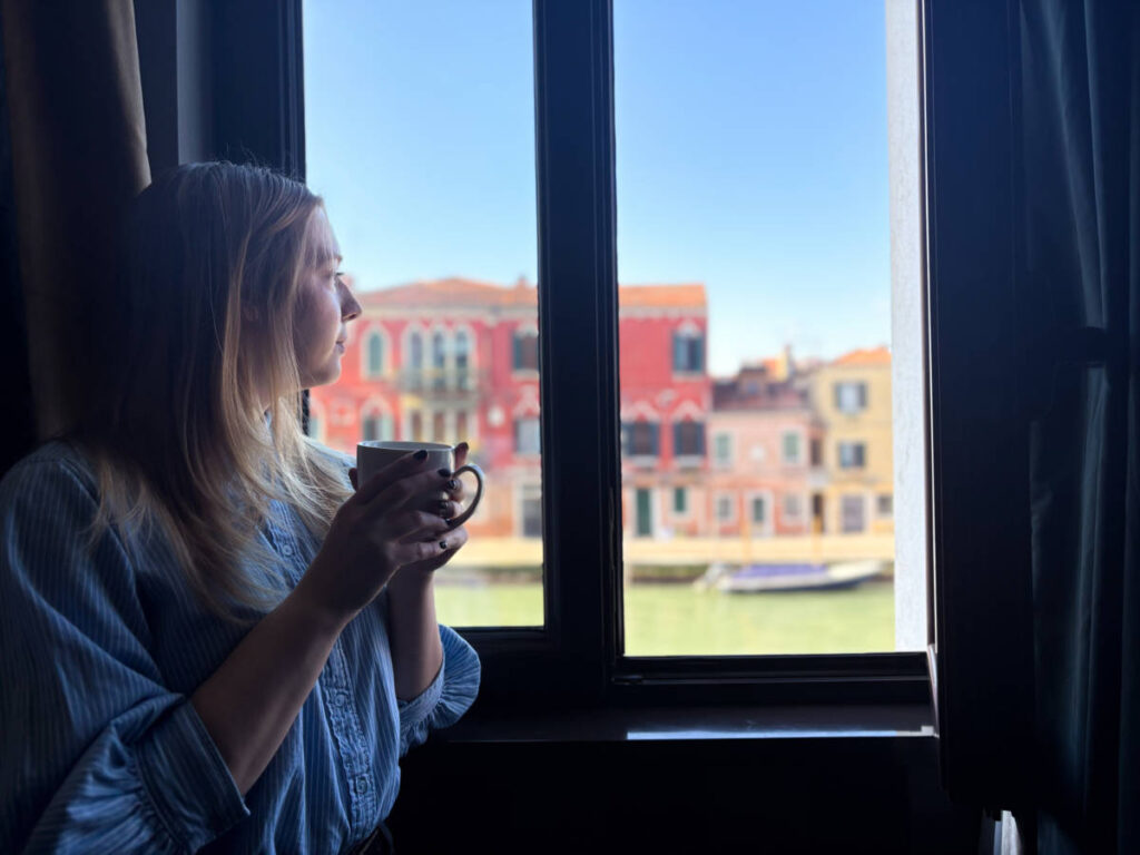 The author Taylor Herperger, admiring the view while drinking from her room at Carnival Palace in Cannaregio
