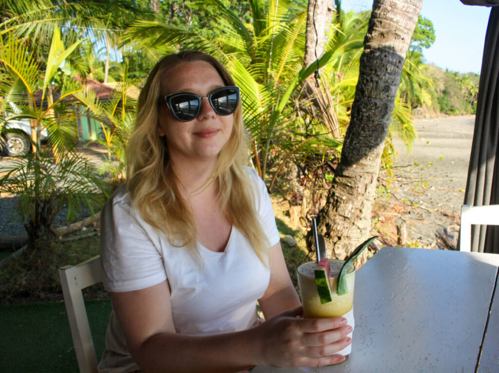 The author Taylor Herperger, holding a glass of pina colada