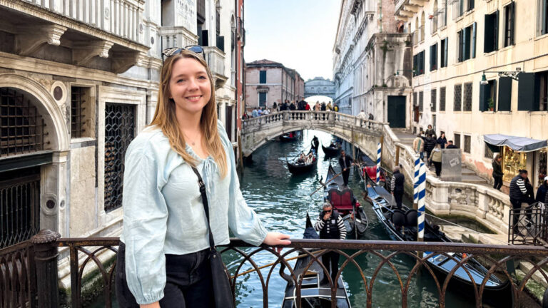 The author Taylor Herperger, standing on the bridge with an overlooking view of the canal in Venice