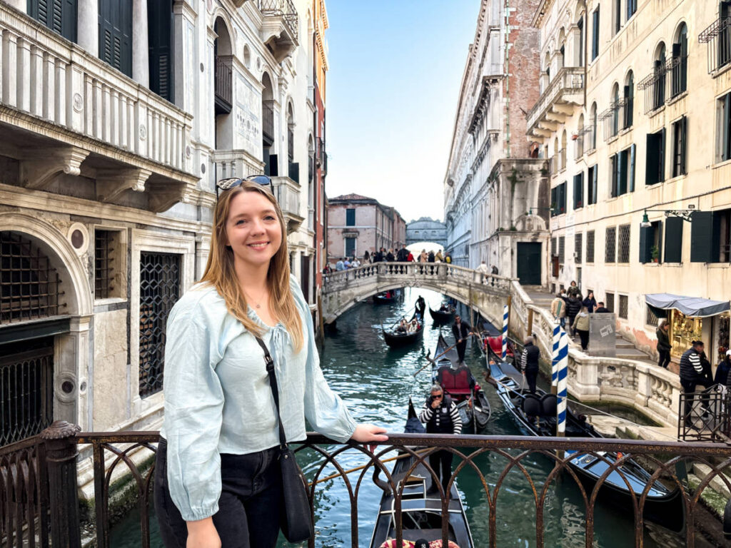 The author Taylor Herperger, smiling for a photo with an overlooking view of the gondolas