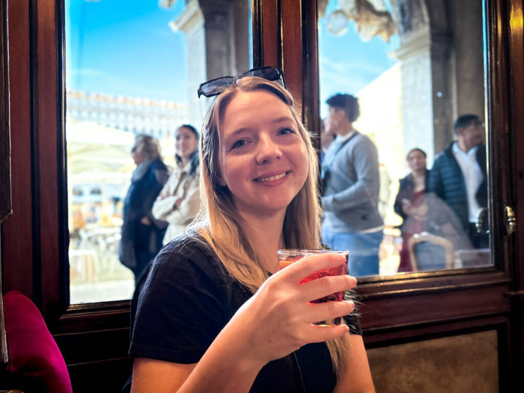 The author Taylor Herperger, holding a glass of “Florian Spritz” at Caffè Florian