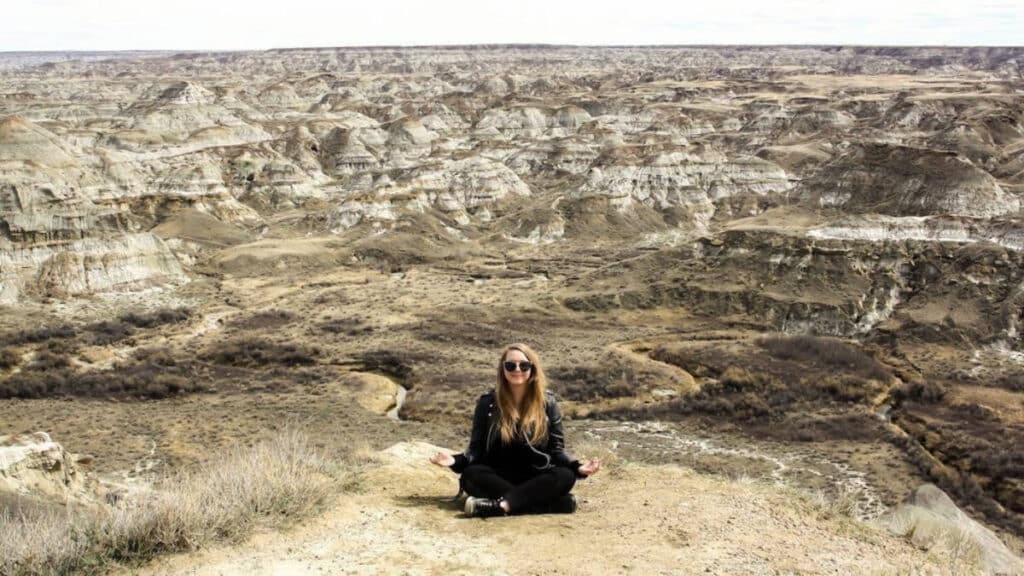 The author Taylor Herperger, on a yoga pose at Dinosaur Provincial Park in Alberta