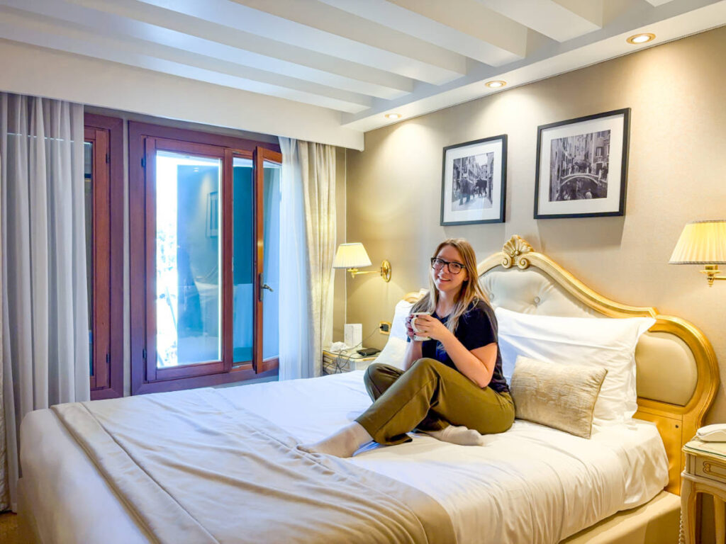 The author Taylor Herperger, enjoying a cup of drink on her bed at Hotel Olimpia