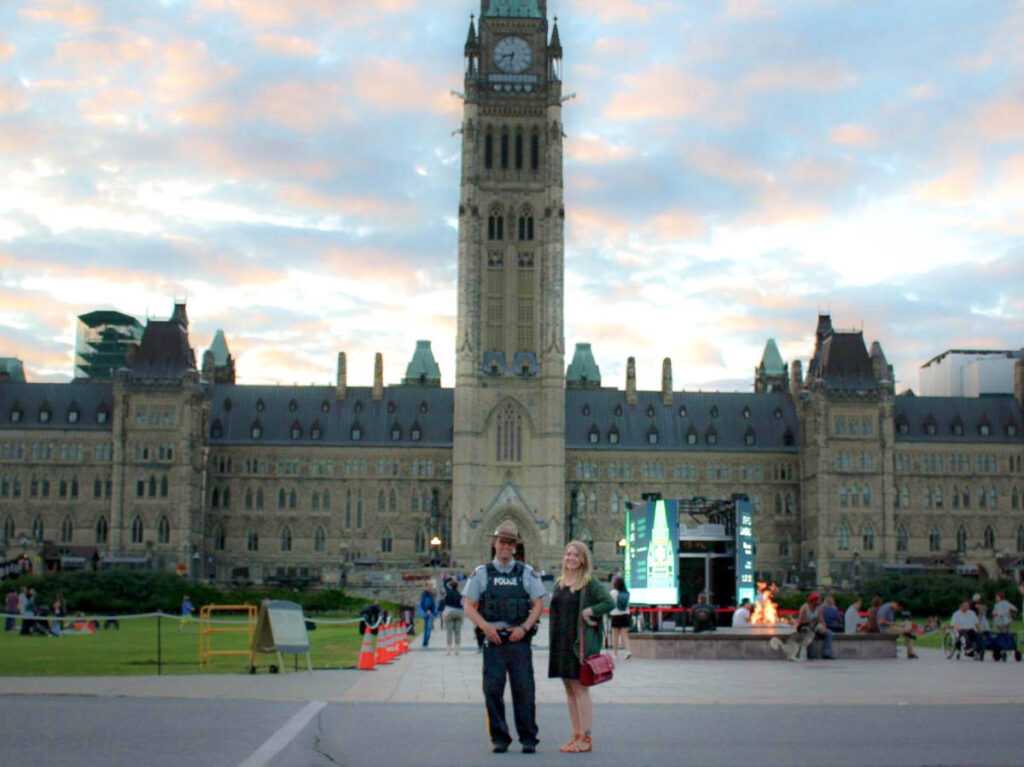 The author Taylor Herperger, smiling for a photo with the security officer at Parliament Hill
