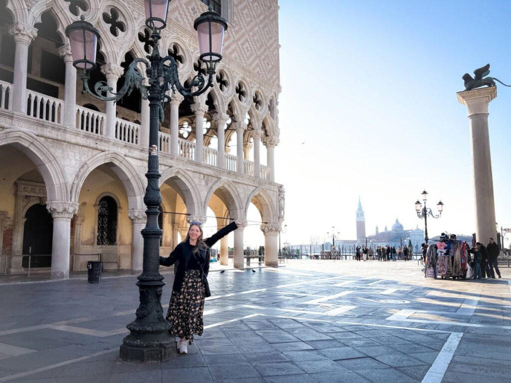 The author Taylor Herperger, enjoying at Piazza San Marco while holding the lamp post