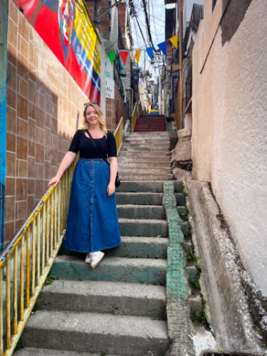 The author Taylor Herperger, posing for a photo on the staircase at an alleyway in Medellin