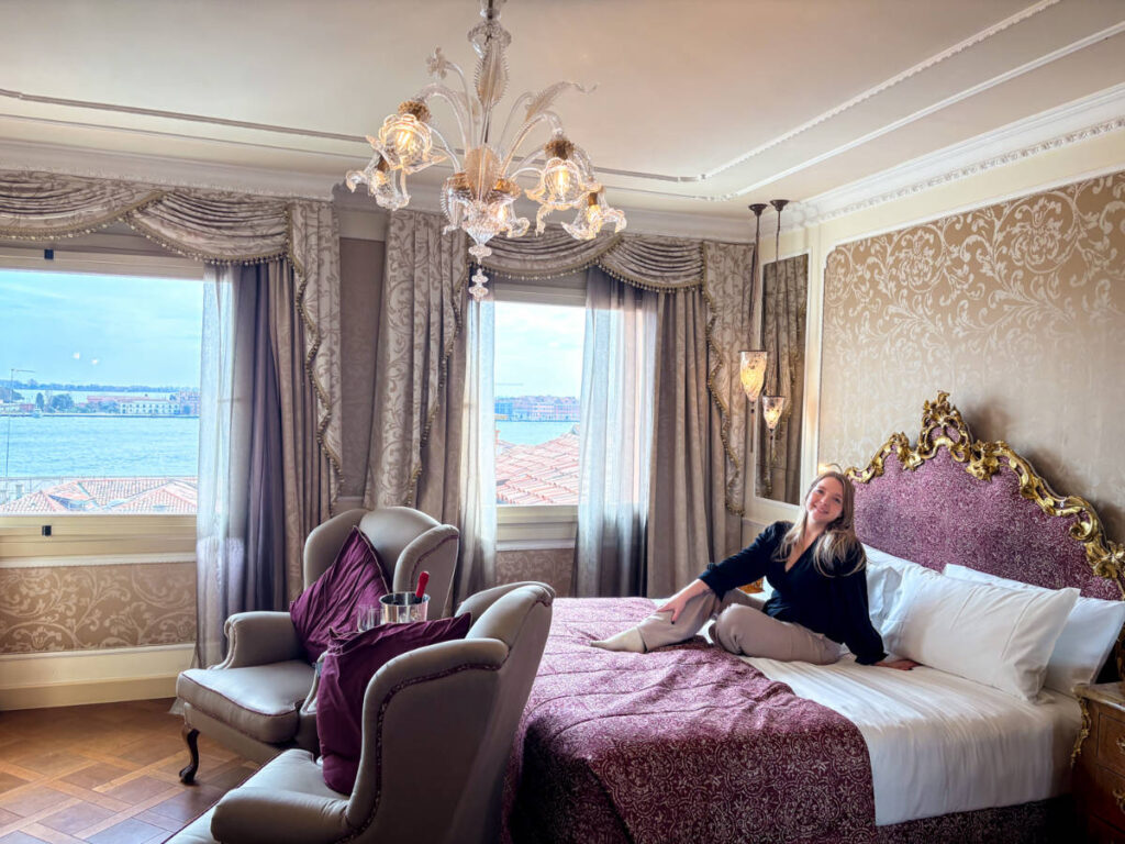 The author Taylor Herperger, sitting on her bed in the Baglioni Hotel Luna