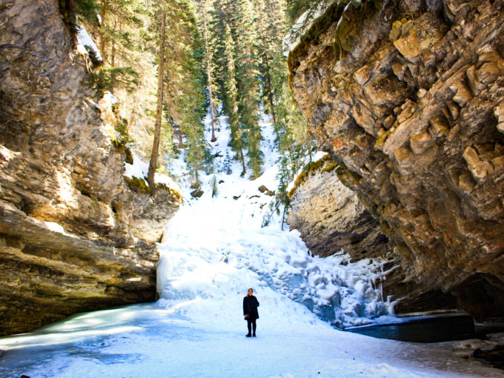 The author Taylor Herperger on the frozen waterfall in Johnston Canyon
