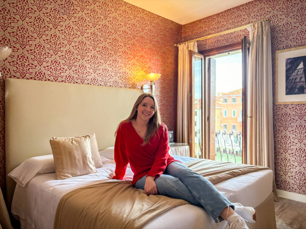 The author Taylor Herperger, sitting on her bed at Hotel Principe