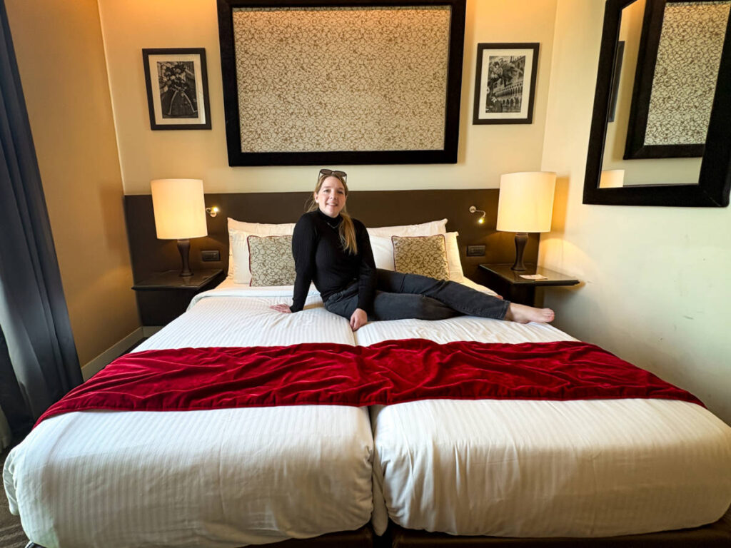 The author Taylor Herperger, hanging out on her bed at Leonardo Royal