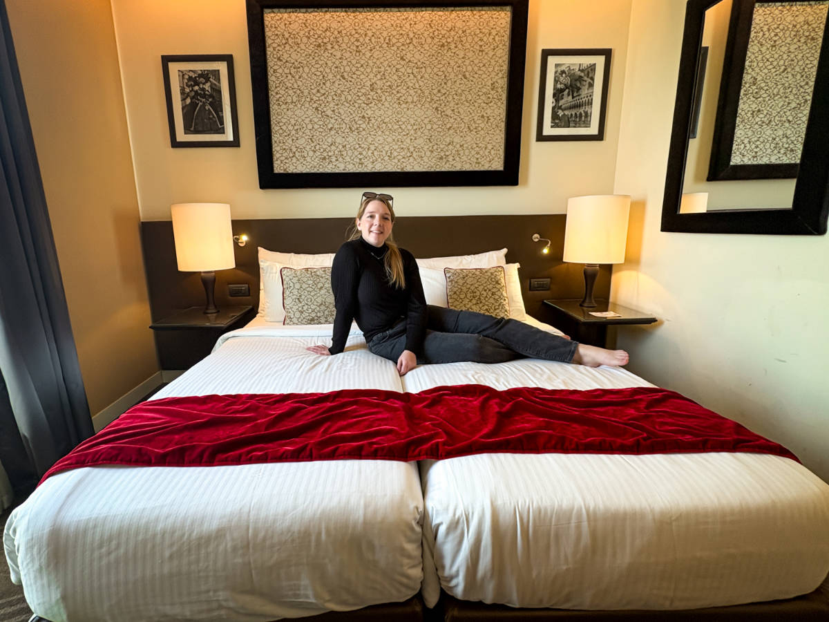 The author Taylor Herperger, hanging out on her bed at Leonardo Royal