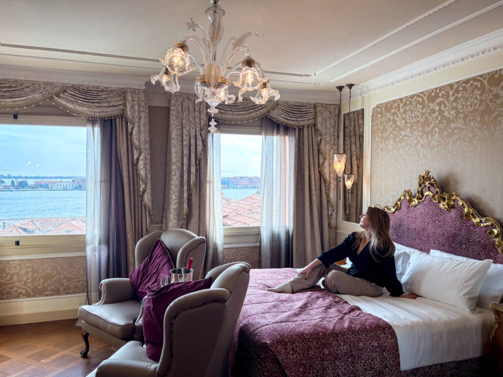 The author Taylor Herperger, admiring the view while sitting on her bed in Baglioni Hotel Luna