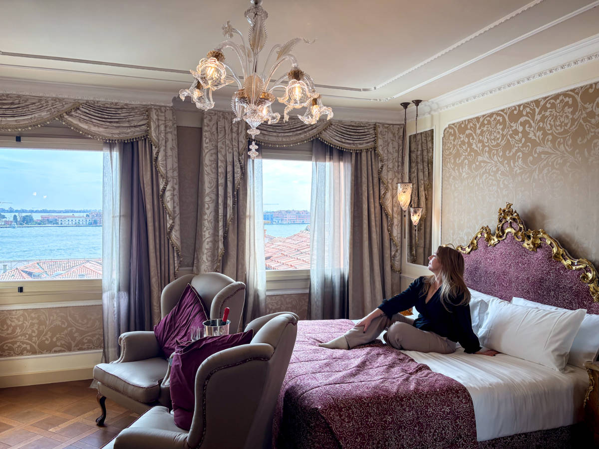 The author Taylor Herperger, admiring the view while sitting on her bed in Baglioni Hotel Luna