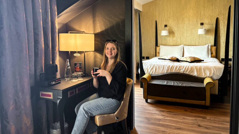 The author Taylor Herperger, sitting while holding a drinking in her suite at Palazzo Veneziano