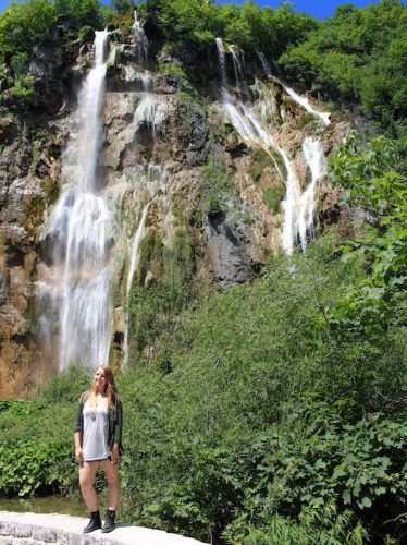 The author Taylor Herperger posing for a photo in front of the  waterfalls in Plitvice Lakes National Park
