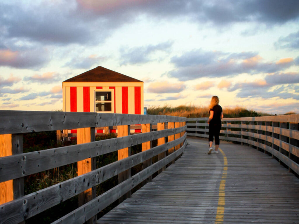 The author Taylor Herperger, running along the boardwalk in Prince Edward Island National Park at sunset