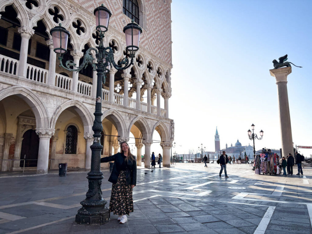 The author Taylor Herperger, leaning on a lamp post in front of Doge’s Palace