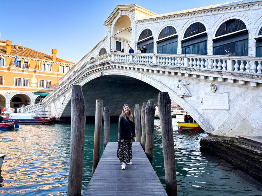 The author Taylor Herperger, smiling for a photo in front of the Rialto Bridge