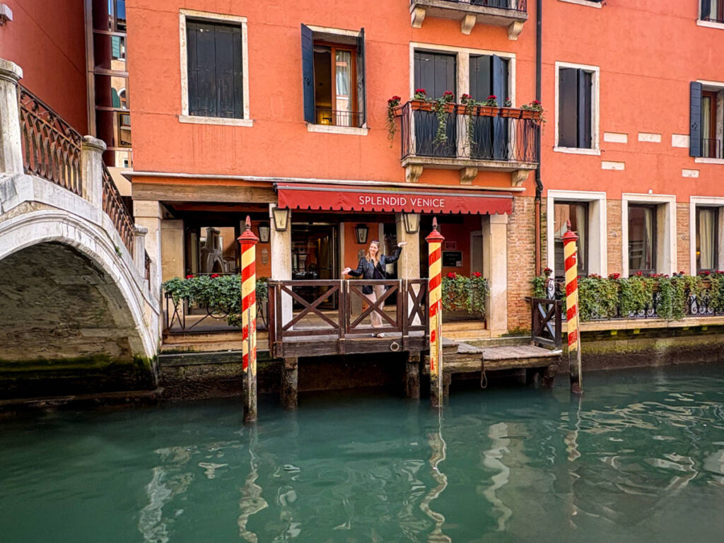 The author Taylor Herperger, posing for a photo in front of the Splendid Venice with the view of the canal