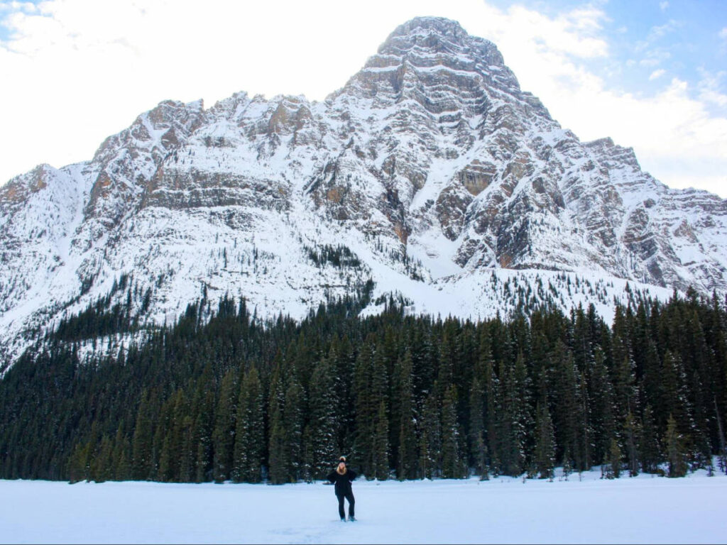 The author Taylor Herperger posing in front of the snow covered mountain in Banff