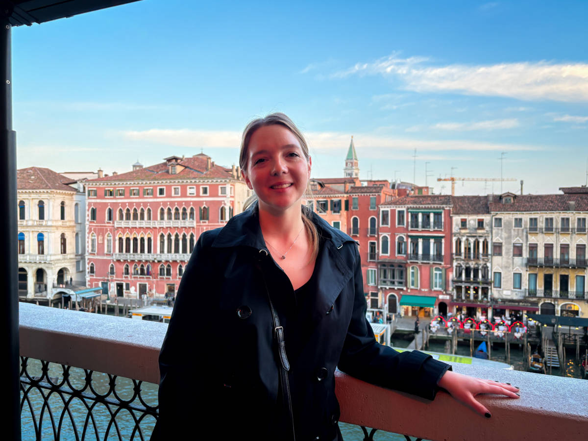 The author, Taylor Herperger, smiling for a photo with an overlooking view on La Terrazza Rooftop Bar