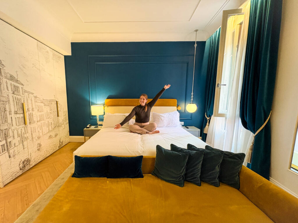 The author, Taylor Herperger sitting on her bed at H10 Palazzo Canova