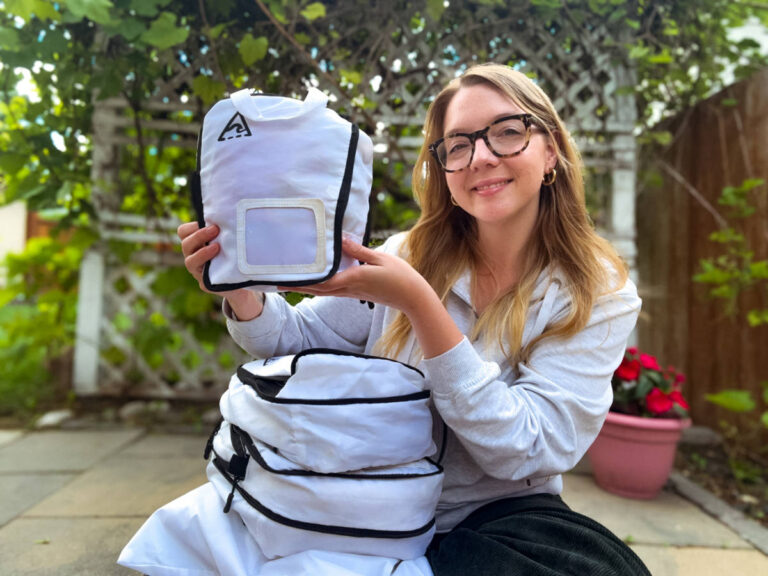 Thea author Taylor Herperger, holding her 4-piece set of Well Traveled Packing Cubes