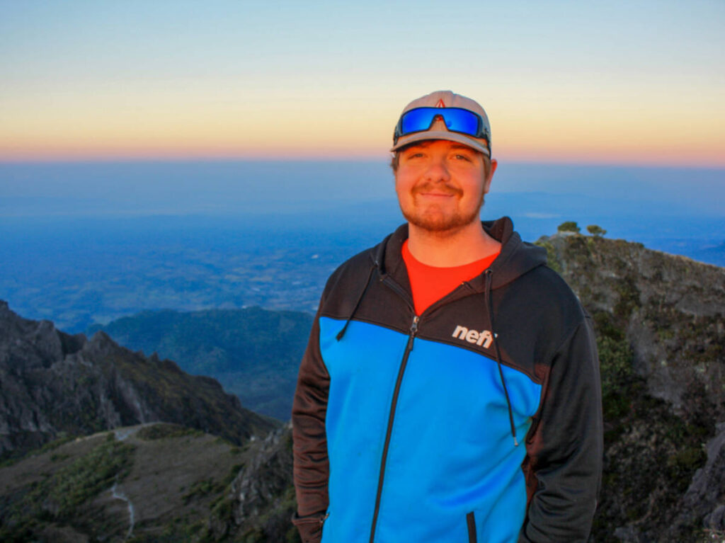 The author's brother, Garrett smiling for a photo on Volcan Baru at sunset
