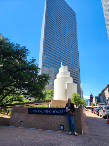 Author Sarah Heath posing in front of Thanks-Giving Square in Dallas